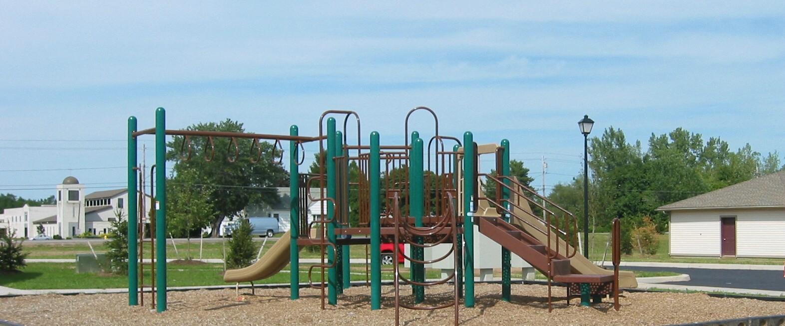 a playground with a slide and climbing equipment in a park