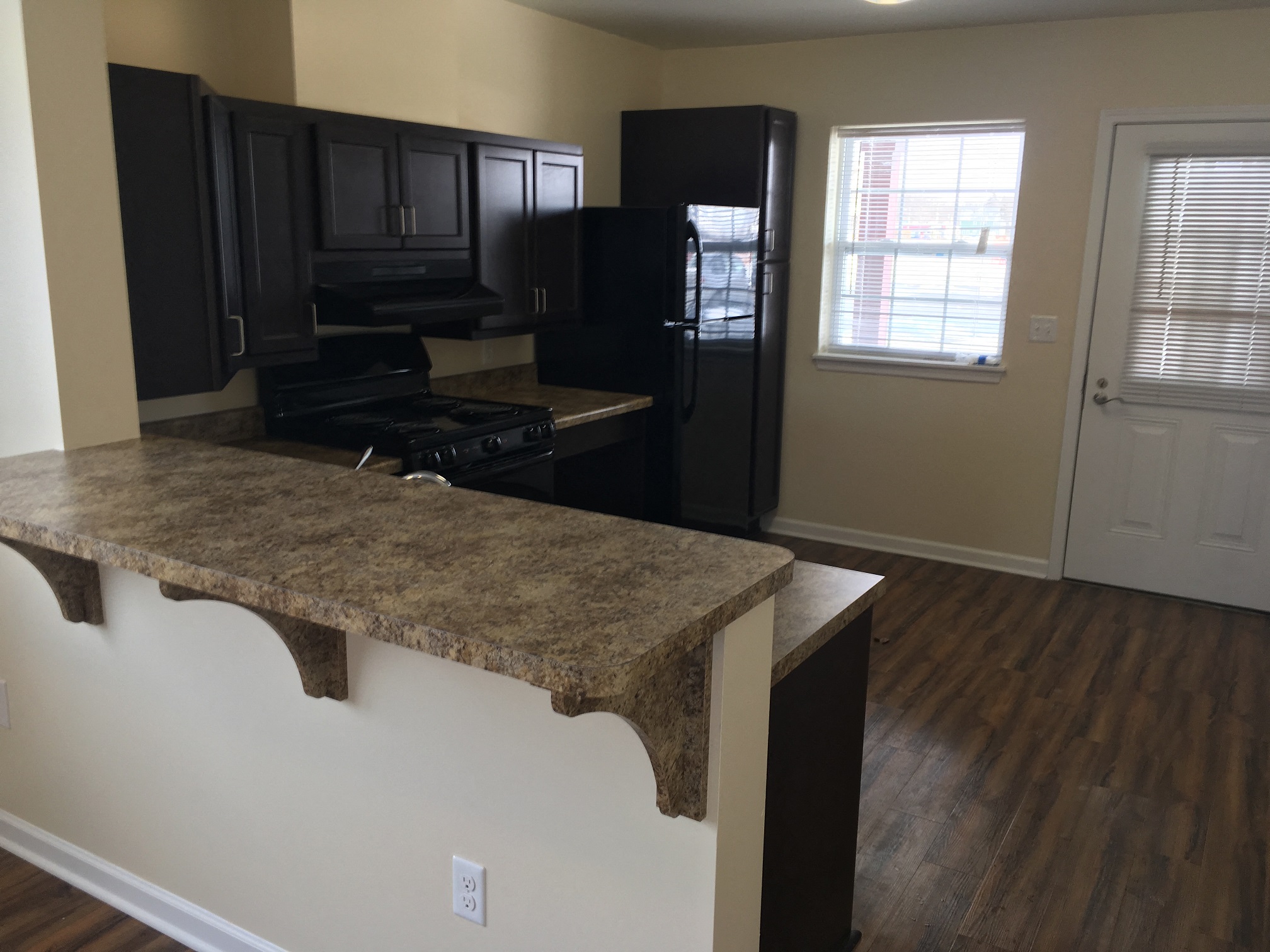 a kitchen with granite counter tops and a black refrigerator