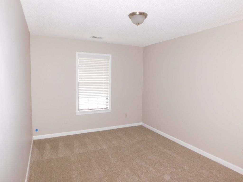 an empty room with carpet and a window