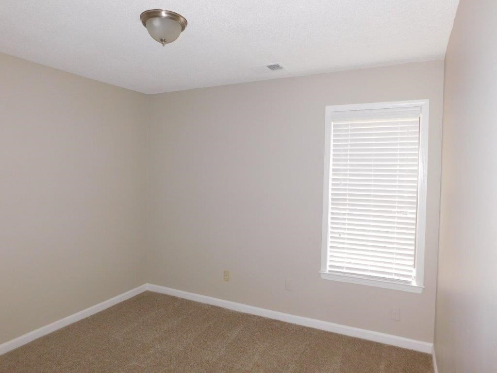 an empty room with a window and a carpet
