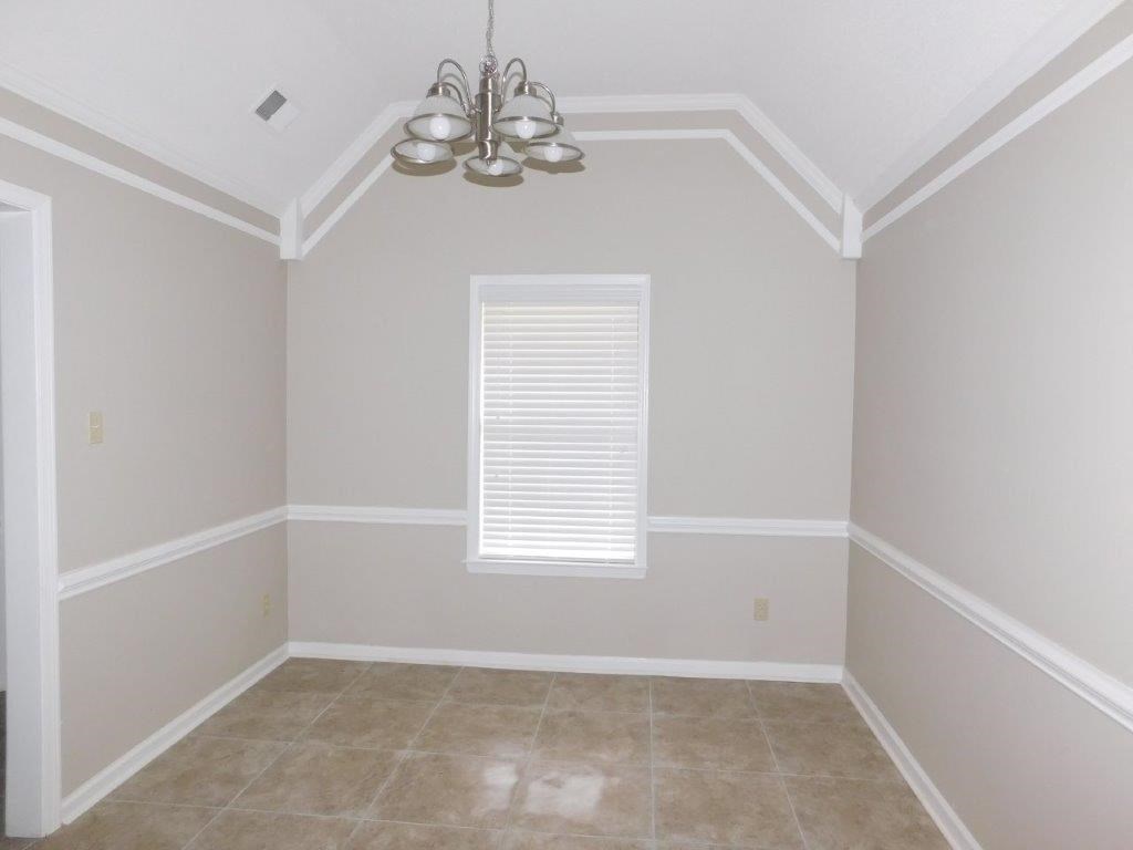 an empty room with a chandelier and a window