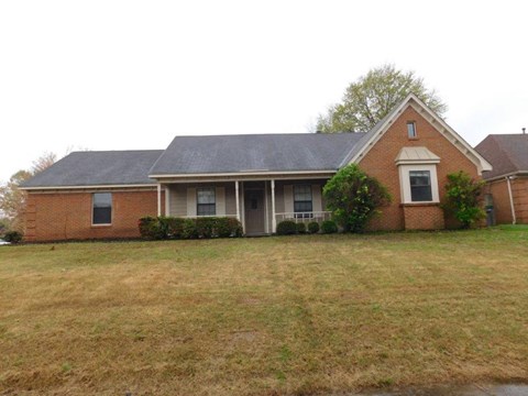 a brick house with a lawn in front of it
