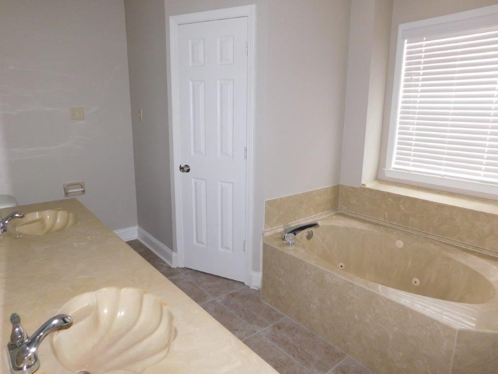 a bathroom with a tub and a sink and a door