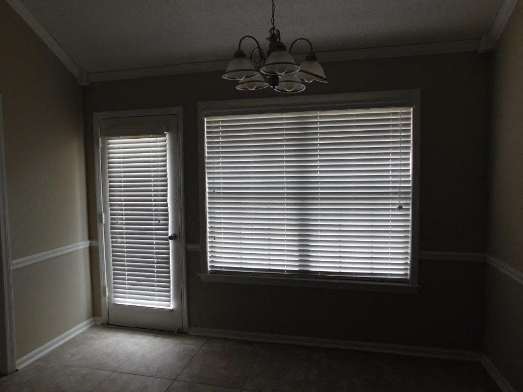 a dark room with a large window and a door