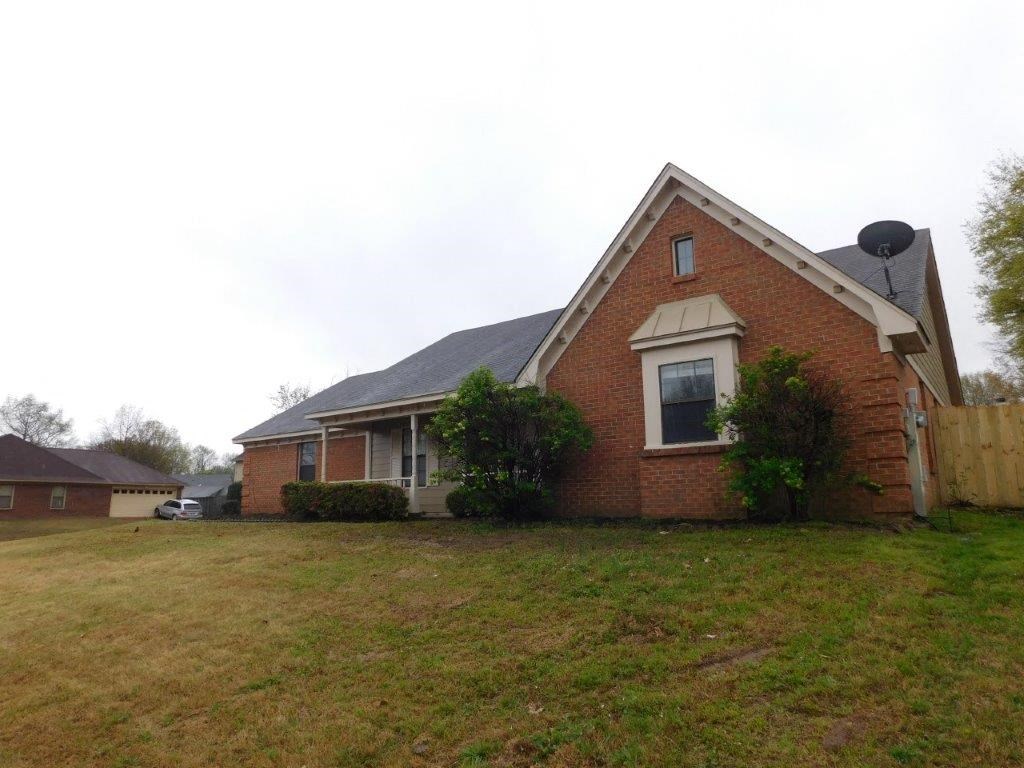 a brick house with a yard and a fence