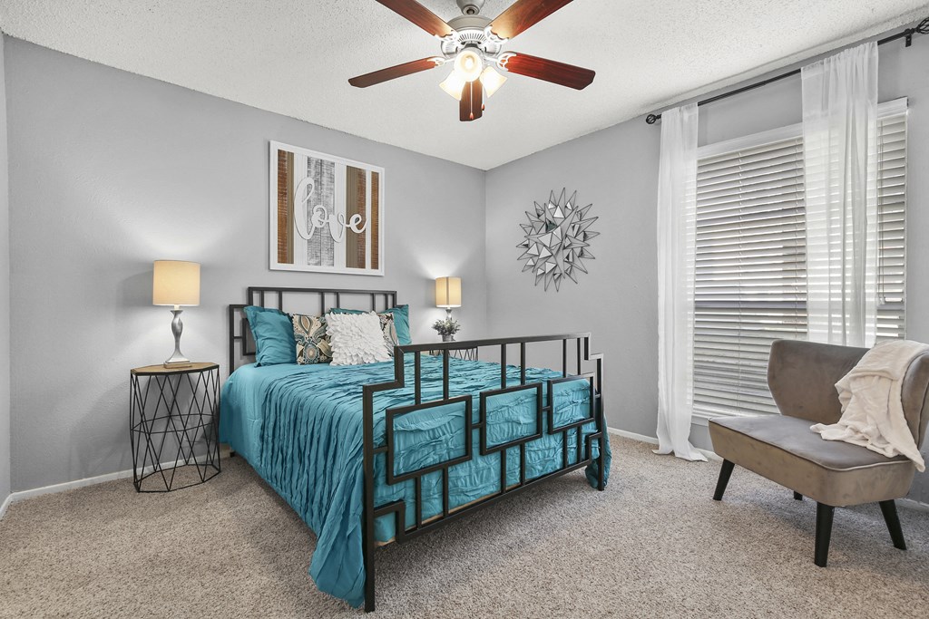 a bedroom with a bed and a ceiling fan