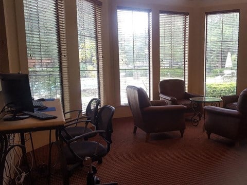 a living room with chairs and a desk with a computer