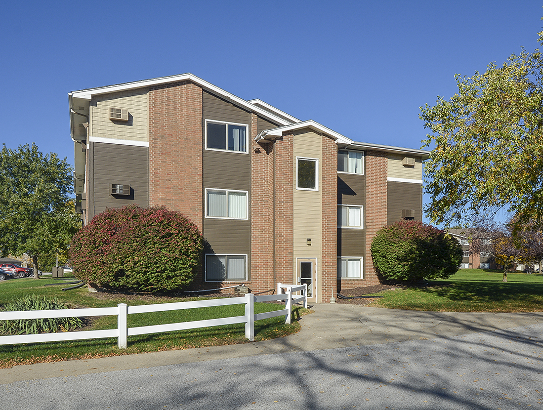 White Fence Leading to an Entrance Door for an Apartment Building at Timberland at Crestburck
