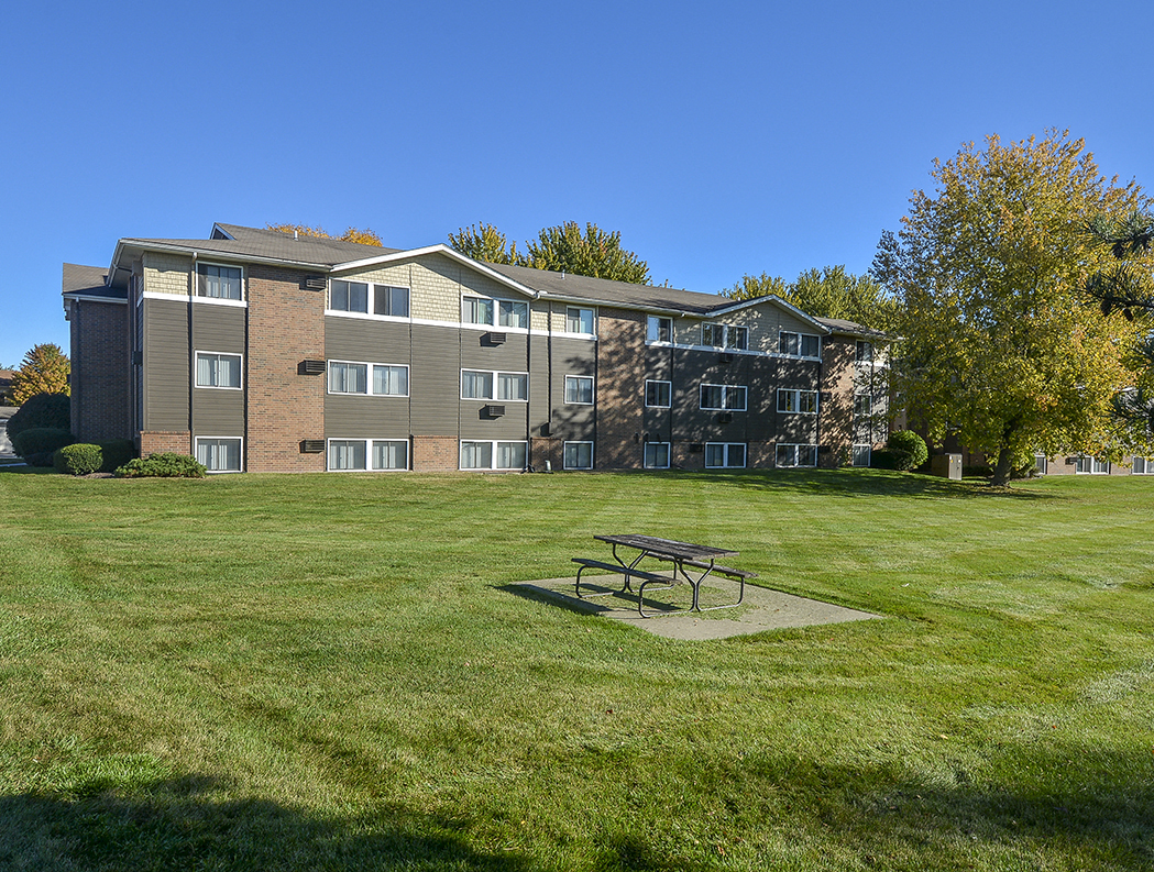 Exterior of a Timberland at Crestbuck Apartment Building Overlooking the Green Grass and Picnic Area