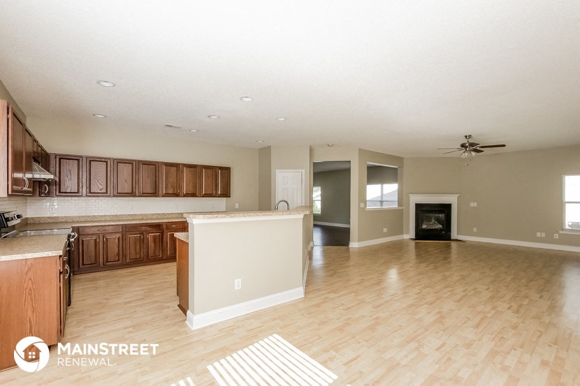 an open kitchen and living room with wood flooring and a fireplace