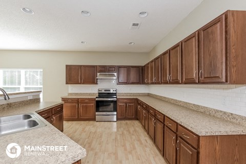 a kitchen with wooden cabinets and granite counter tops and a sink