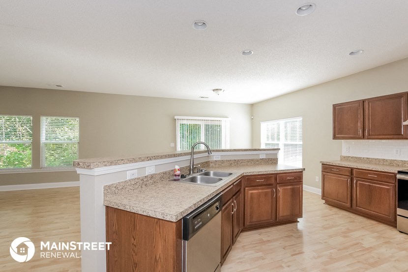 a kitchen with wooden cabinets and granite counter tops and a sink