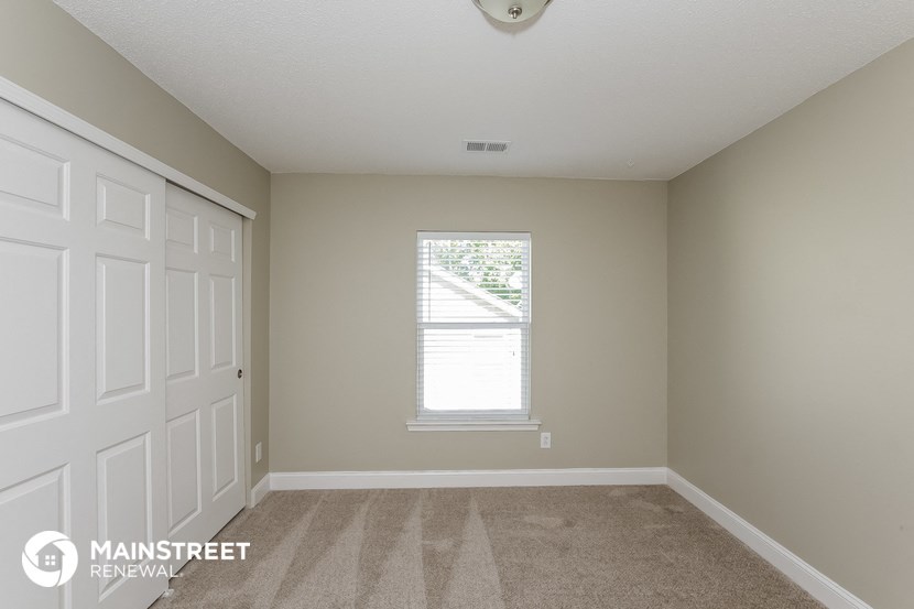 a bedroom with a white door and a window