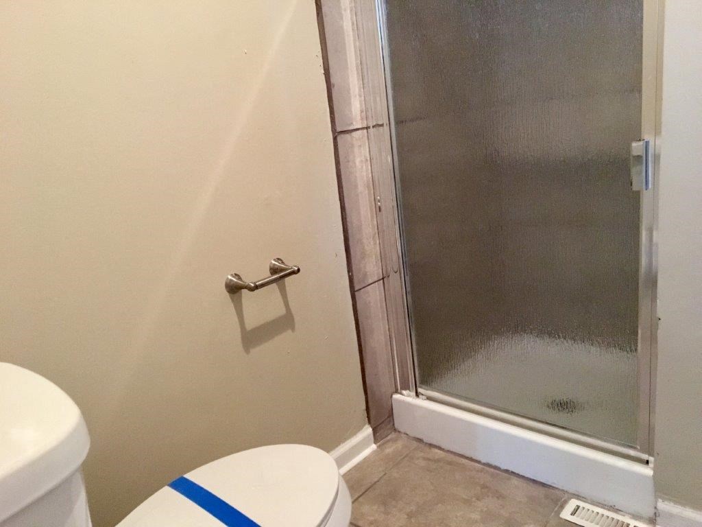 a bathroom with a toilet and a shower