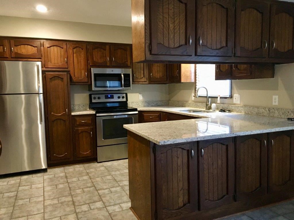 a kitchen with wooden cabinets and stainless steel appliances