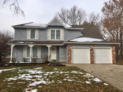 a blue house with snow on the ground