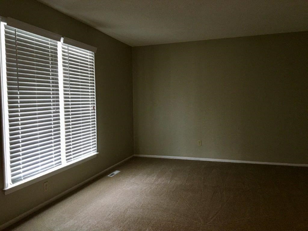 an empty room with a large window with blinds