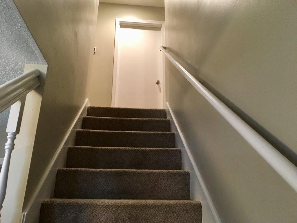 stairs leading up to a basement with a white door