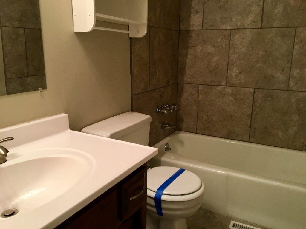 a bathroom with a toilet and a sink and a bath tub