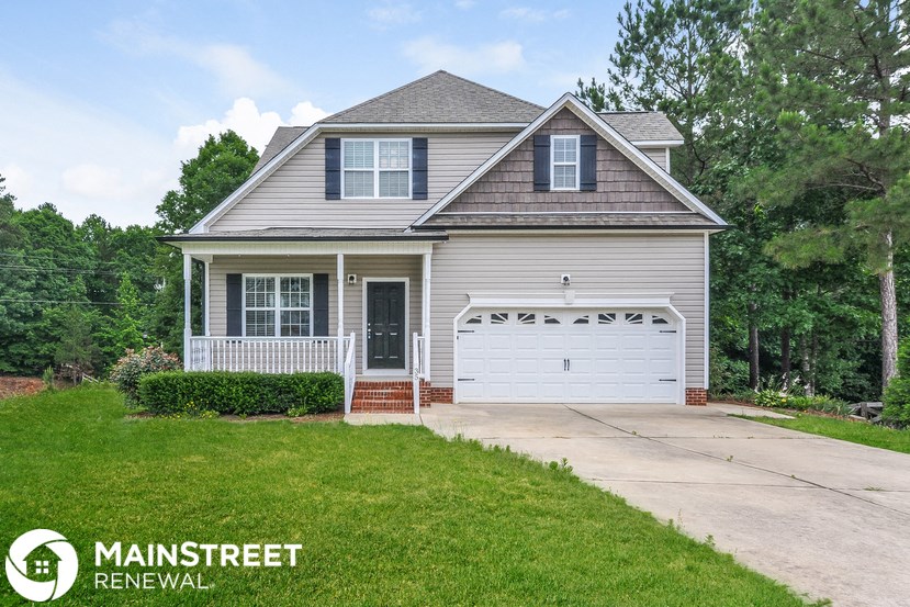 a home with a white garage door and a driveway