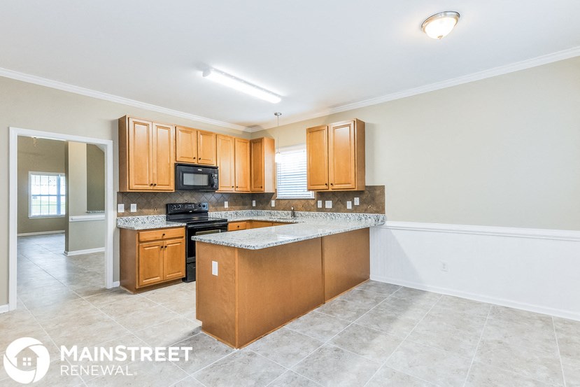 a kitchen with wooden cabinets and granite counter tops and a stove and microwave