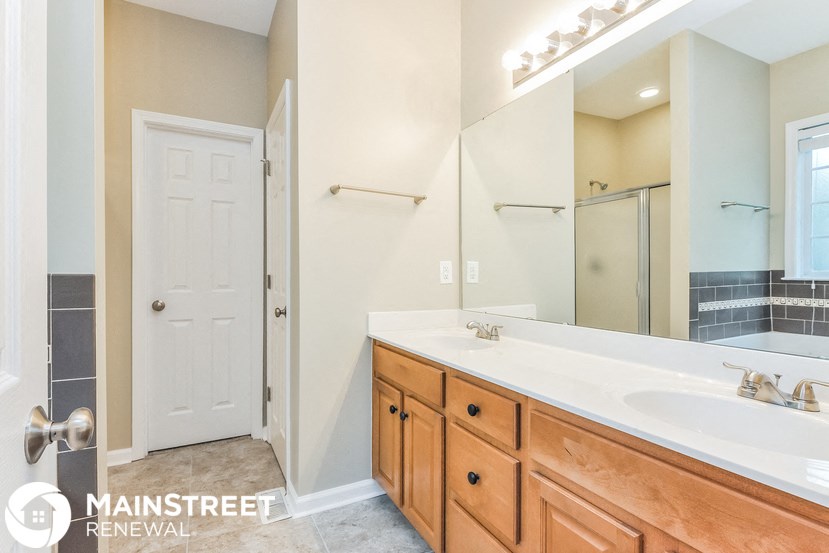 a bathroom with a large mirror and a sink and a shower