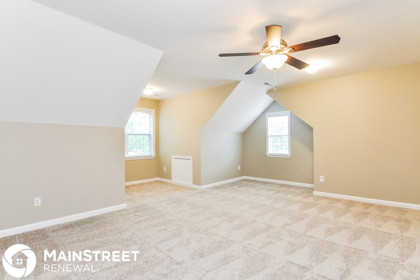 the master bedroom is spacious with vaulted ceilings and a ceiling fan