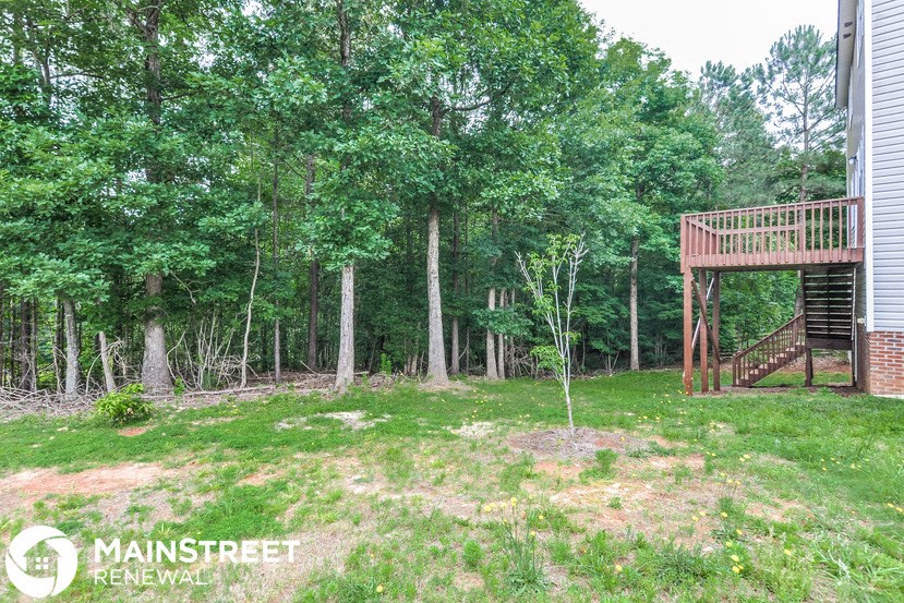 a backyard with a deck and a tree