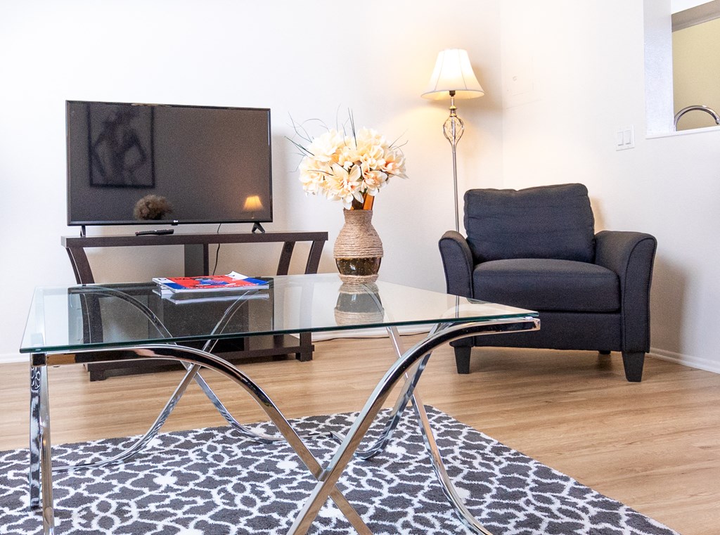 a living room with a glass table and a tv