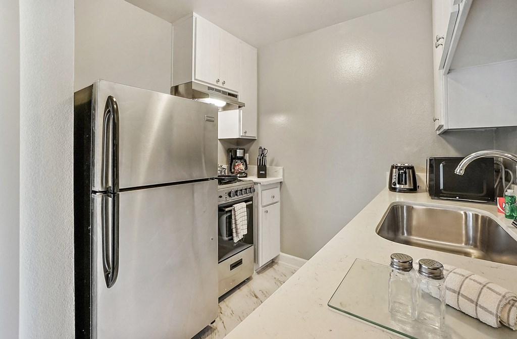 a kitchen with stainless steel appliances and white cabinets