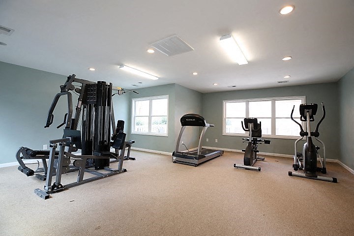 a home gym with exercise equipment and windows