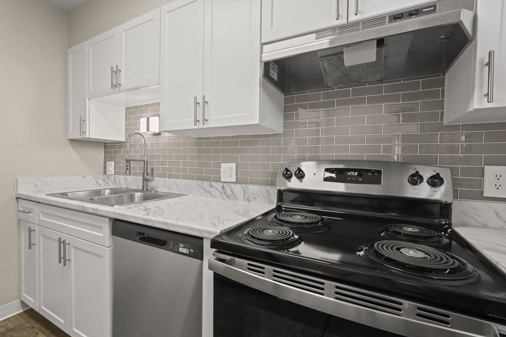 a kitchen with white cabinets and black appliances and a sink