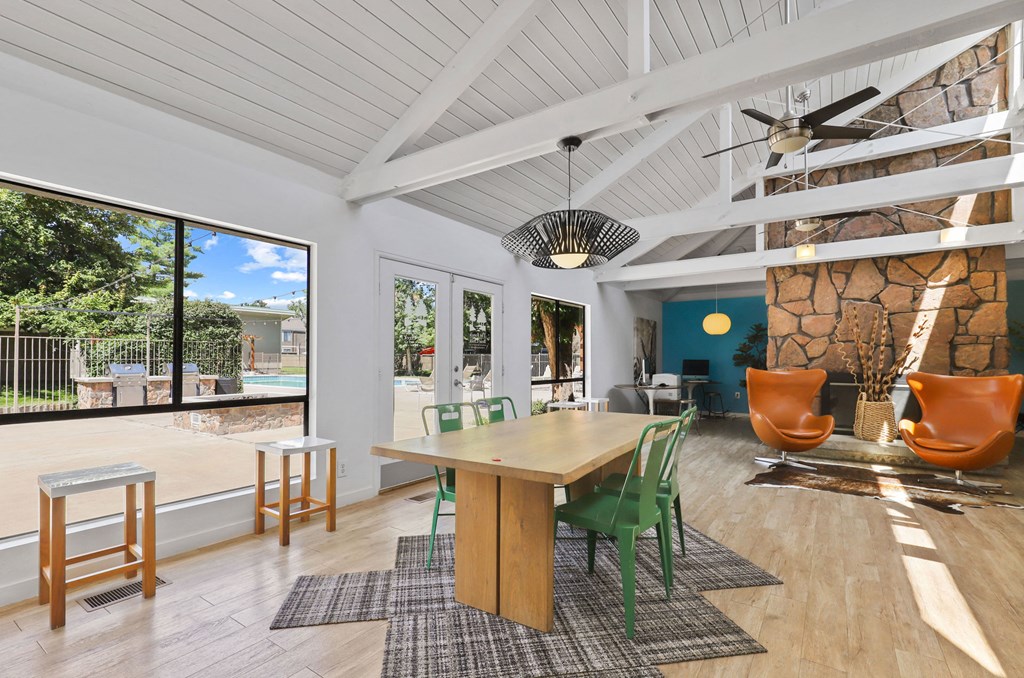 a dining room with a table and chairs and a large window