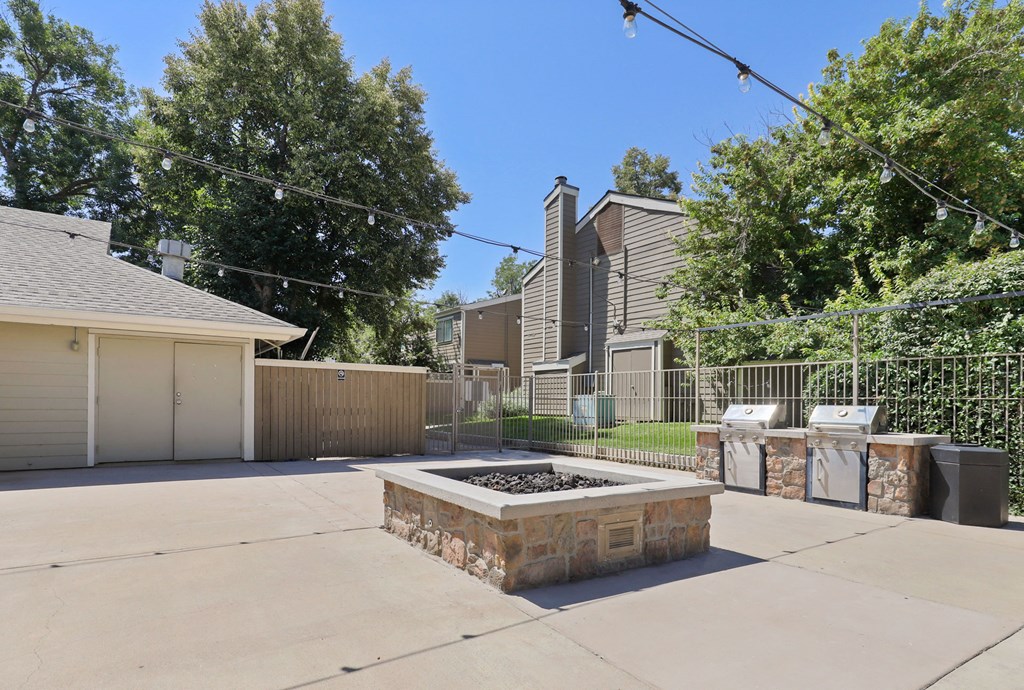 the backyard of a house with a fire pit and a fence