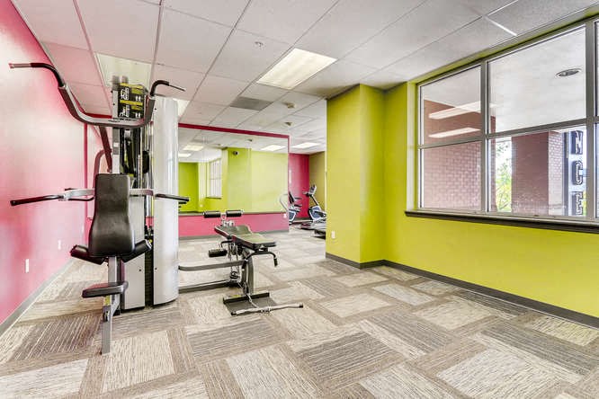 a workout room in a building with gym equipment and a large window