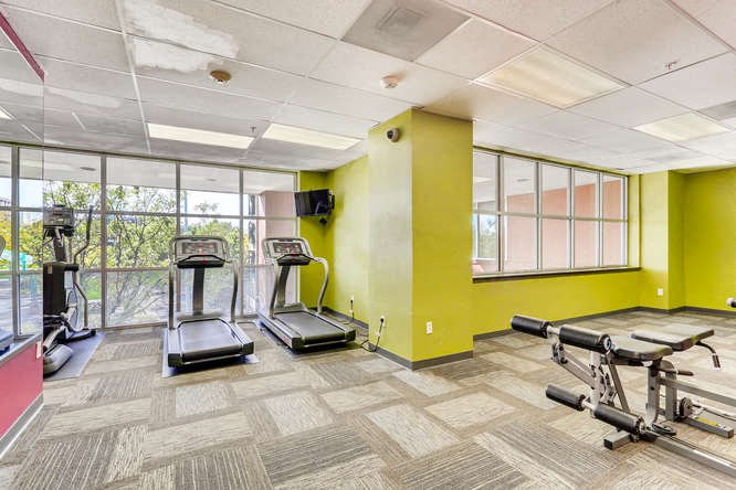 a gym with exercise equipment and windows in a building