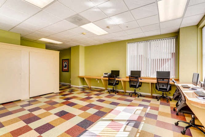 an office with desks and chairs and a checkered floor