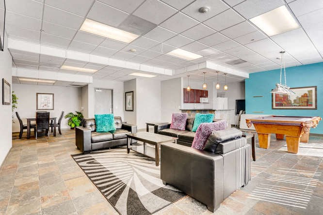 a living room with a pool table and couches