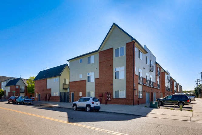an apartment building with cars parked in front of it