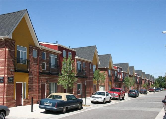 a row of houses with cars parked on the street