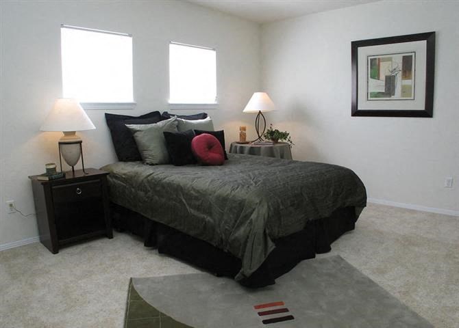 a bedroom with a bed and two lamps