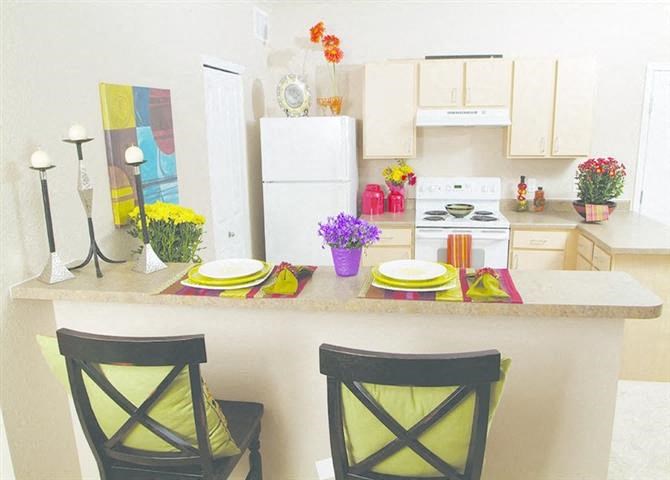a kitchen with a counter and two chairs