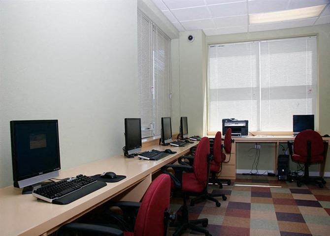 a room with a long desk with computers on it