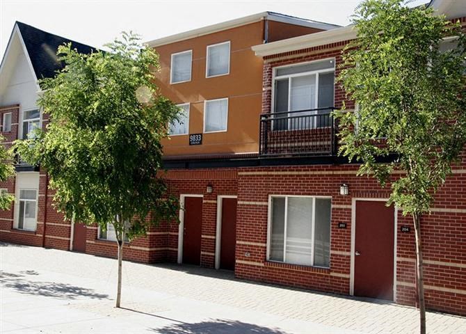 a red brick building with two trees in front of it