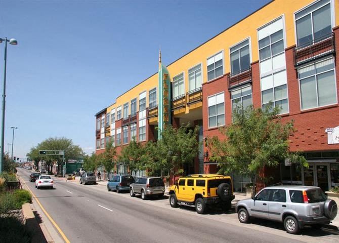 a street with cars parked in front of a large building