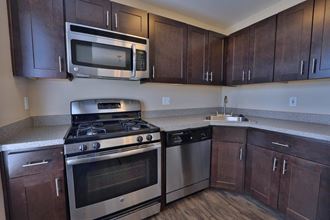 a kitchen with stainless steel appliances and wooden cabinets