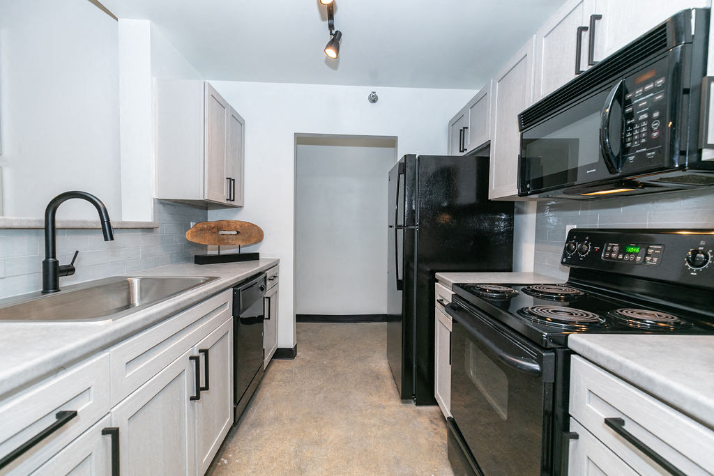 a kitchen with black appliances and white cabinets