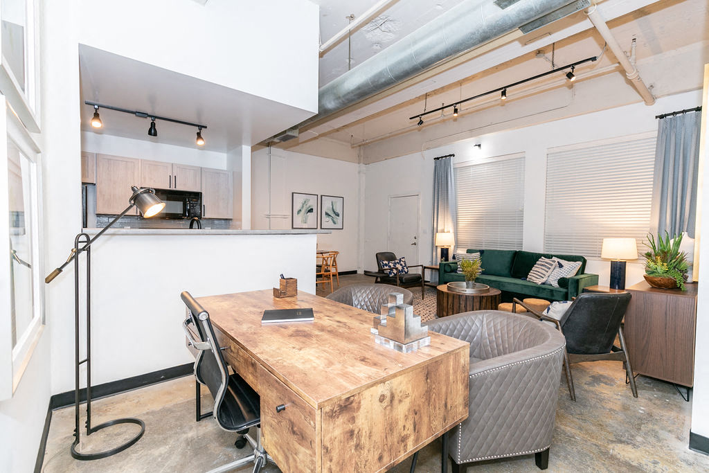 a living room with a table and a kitchen