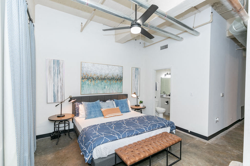 a bedroom with a bed and a ceiling fan