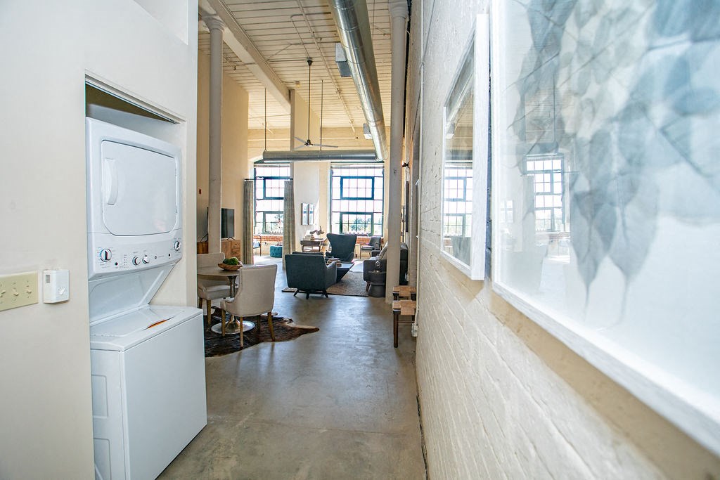 a laundromat with a washing machine and a dryer in a long room
